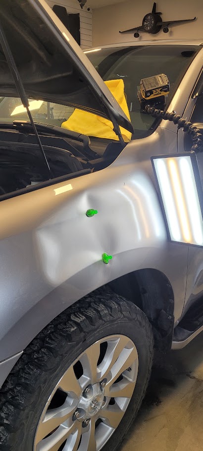 Same silver fender after paintless dent repair, flawless finish